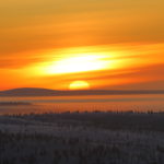 sunset over snowy landscape in finland