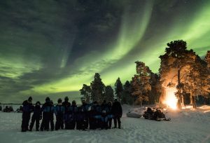 Big family group taking a picture under the northern lights