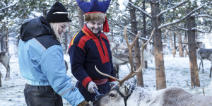 Guests feeding reindeer with local people