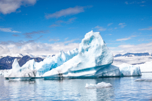 Glacier floating over water in Iceland with a blue sky