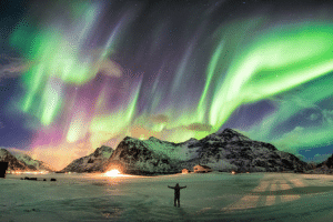 Man standing under the beautiful Northern Lights in Norway