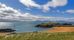 View across a beach in Anglesey in Wales with clear blue waters