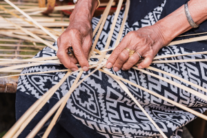 Local Ugandan woman weaving a basket by hand