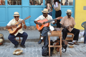 Group of cubans plaing guitars in the bright streets of Havana