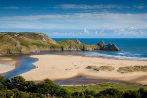 View over a sandy beach with cliffs in Wales