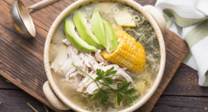 A bowl of traditional colombian Ajiaco with vegetables and chicken