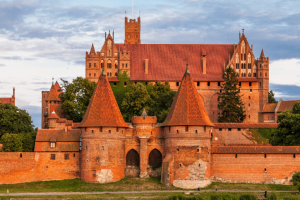 Malbork castle in Poland with orange brick against a cloudy sky