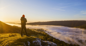 Man standing on the edge of a mountain in Wales on a UK walking retreat 