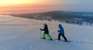 Couple snowshoeing in Lapland as the sun sets