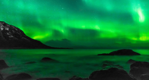 The northern lights floating in Norway over a lake