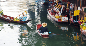 Local people riding in a long-tail river boat along one of Thailand's rivers